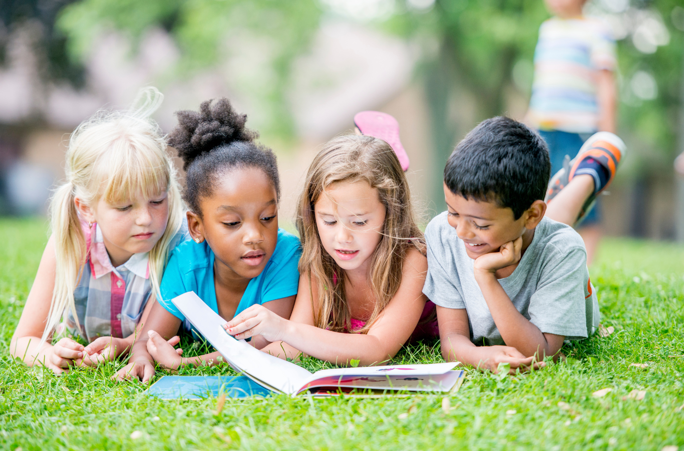 A group of kids reading together outside.