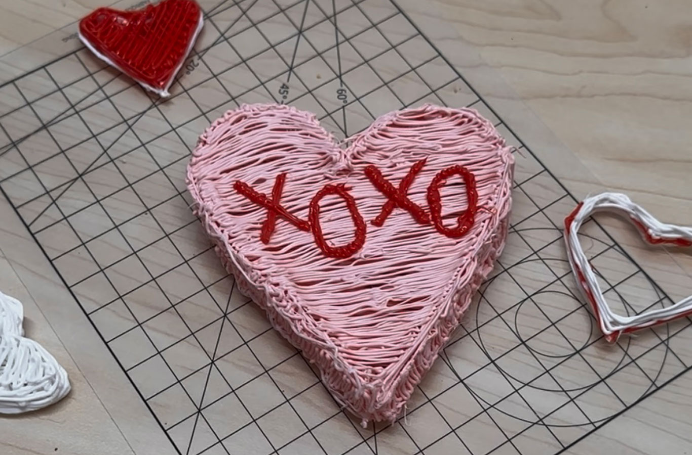 A pink 3D heart similar to candy hearts that says XOXO and was made with the 3Doodler